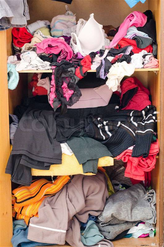 Pile of carelessly scattered clothes in wardrobe, stock photo