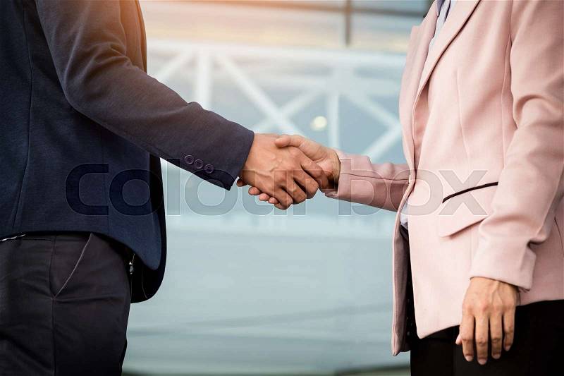 Closeup friendly meeting handshake between business woman and businessman with sunlight, stock photo