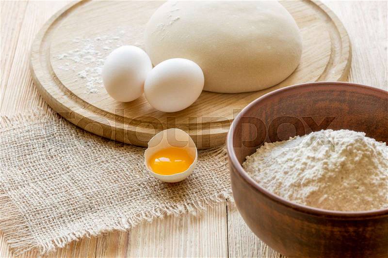 Ingredients for cooking dough, sweet baking. Bowl of flour, butter and eggs on a cutting board, stock photo