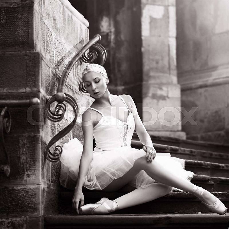 Graceful beauty. Monochrome shot of a young ballerina posing on stone stairs, stock photo