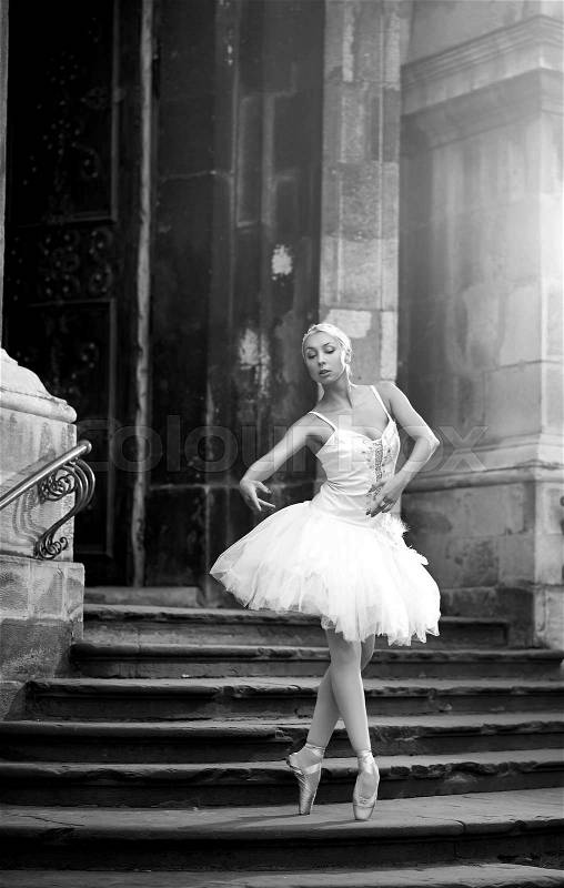 Dancing is her passion. Stunning ballerina dancer posing outdoors near an old castle monochrome soft focus , stock photo