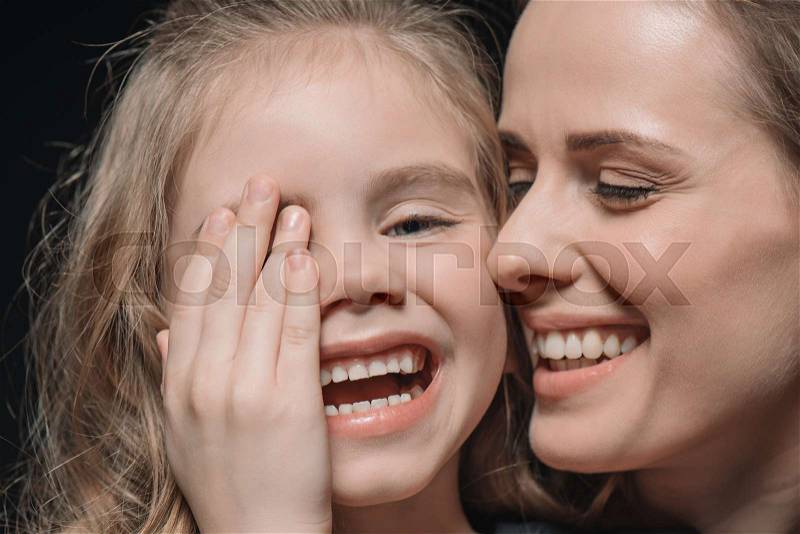 Portrait of daughter and mother laughing on black, stock photo