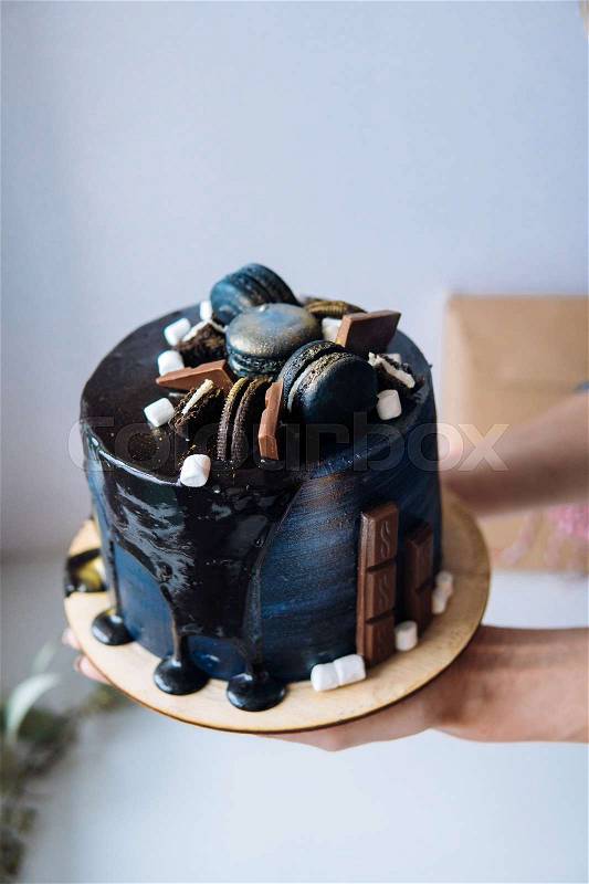 Beautiful designer chocolate cake someone holds on hands, stock photo