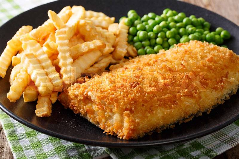 Traditional British food: Fish and chips with green peas close-up on a plate on a table. horizontal , stock photo