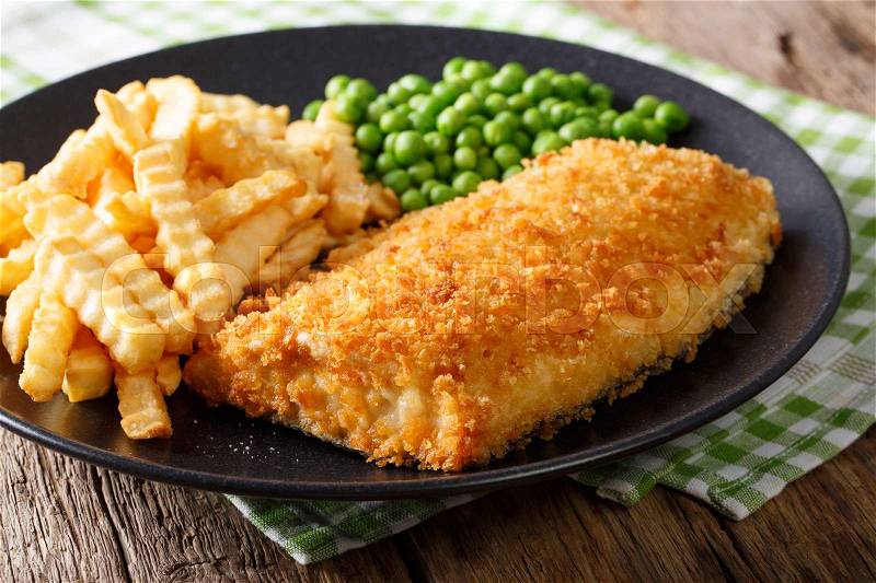 Fish and chips with green peas close-up on a plate on a table. horizontal , stock photo