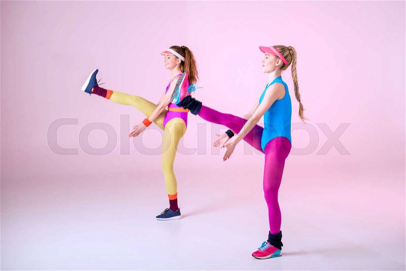 Young sporty women doing aerobic exercises on pink, stock photo