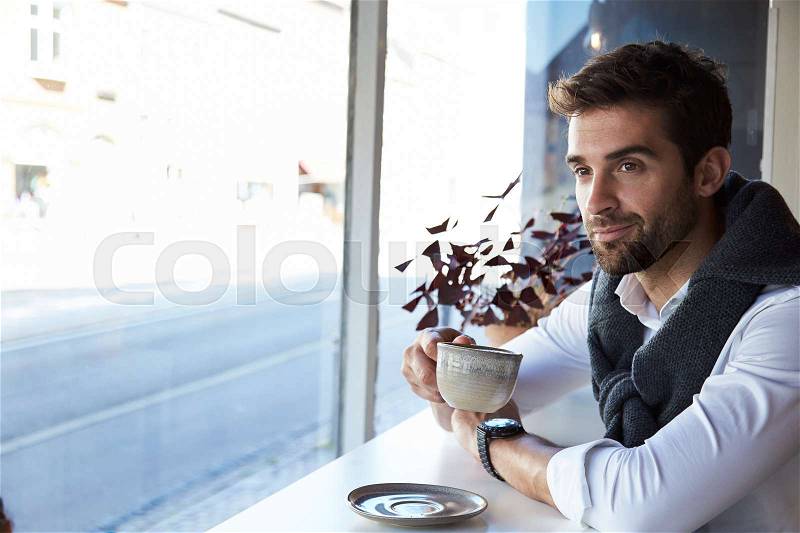 Man taking a coffee break in cafe, stock photo
