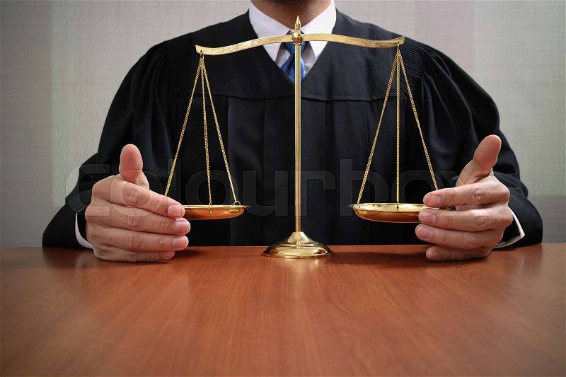 Justice and law concept.Male judge in a courtroom with the balance scale on wood table, stock photo