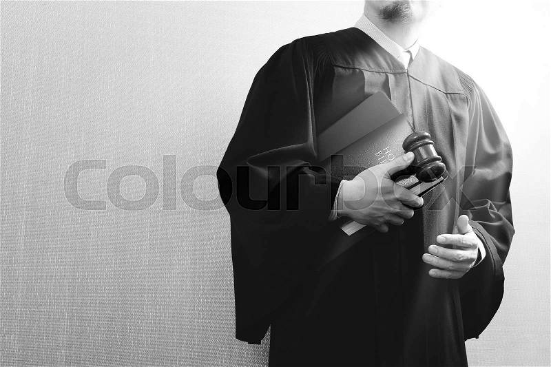 Justice and law concept.Male judge in a courtroom with the gaveland holy book and digital tablet computer, stock photo