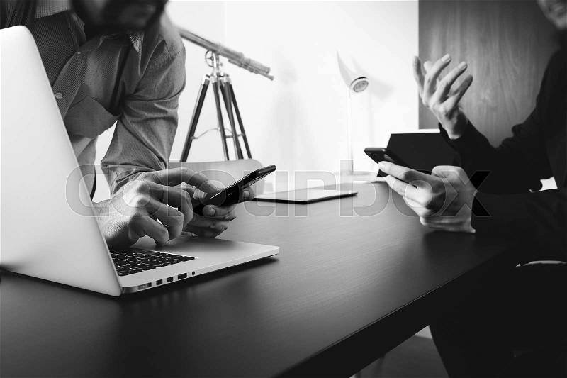 Co working team meeting concept,businessman using smart phone and digital tablet and laptop computer in modern office,black and white , stock photo