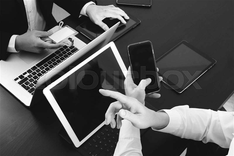 Co working team meeting concept,businessman using smart phone and digital tablet and laptop computer and name tag in modern office,black and white, stock photo