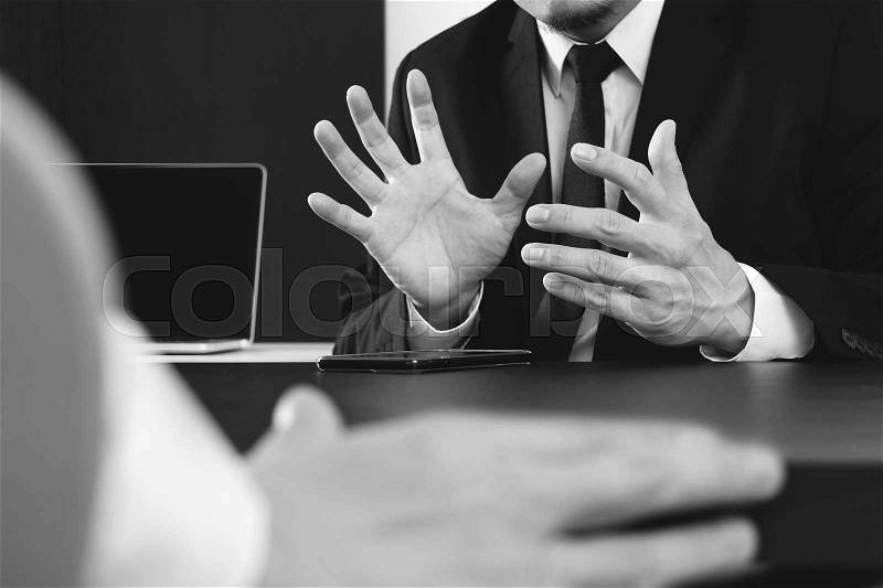 Co working team meeting concept,businessman using smart phone and digital tablet and laptop computer in modern office ,black and white , stock photo