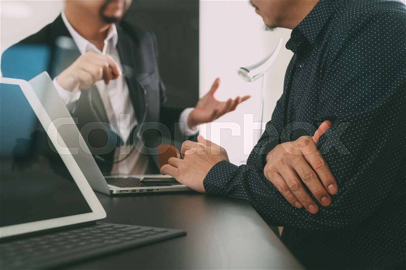 Co working team meeting concept,Man using VOIP headset with digital tablet and latop computer and smart phone in modern office, stock photo