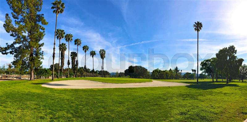 Green golf field and blue cloudy sky. american landscape, stock photo