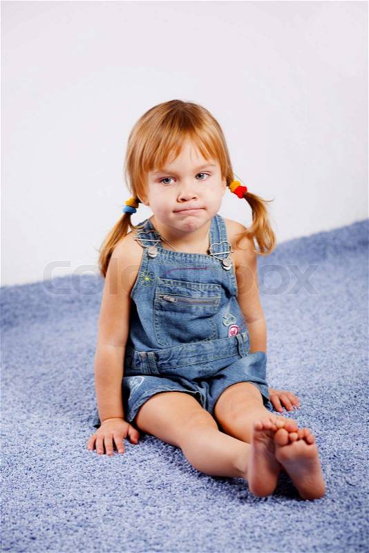 Funny playful little girl on blue carpet  Stock Photo 