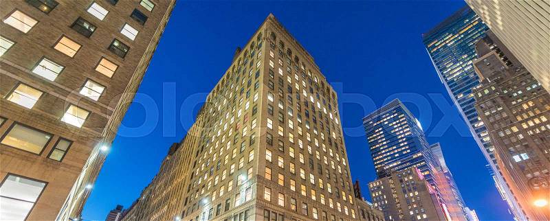 Night view of New York buildings from street level, stock photo