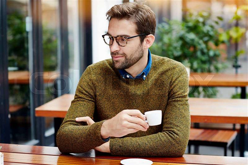 Guy holding coffee cup, smiling, stock photo