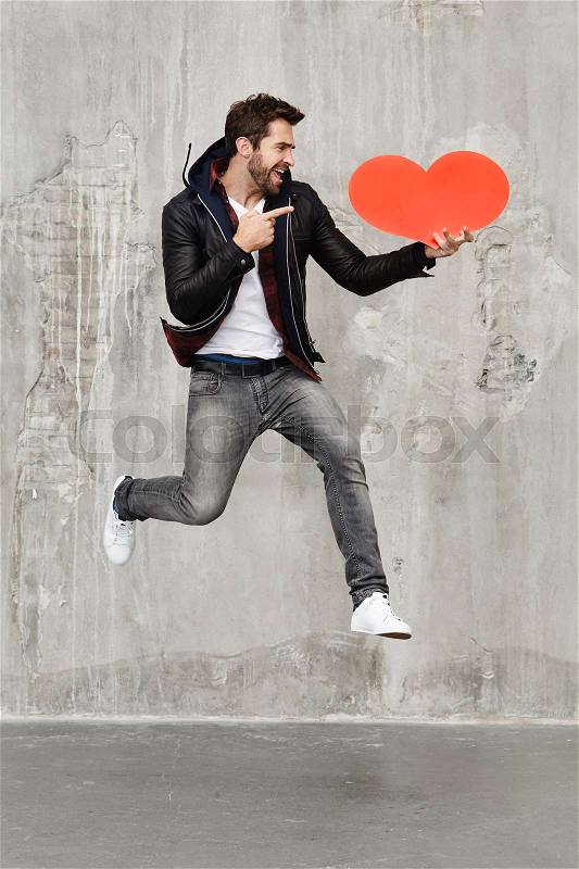 Heart man jumping in studio, stock photo