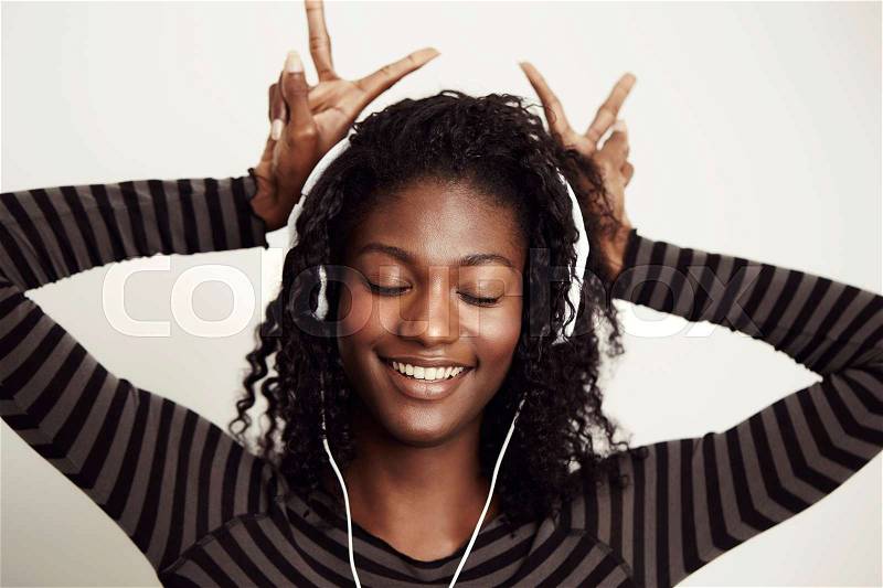 Beautiful model serenely lost in music, smiling, stock photo