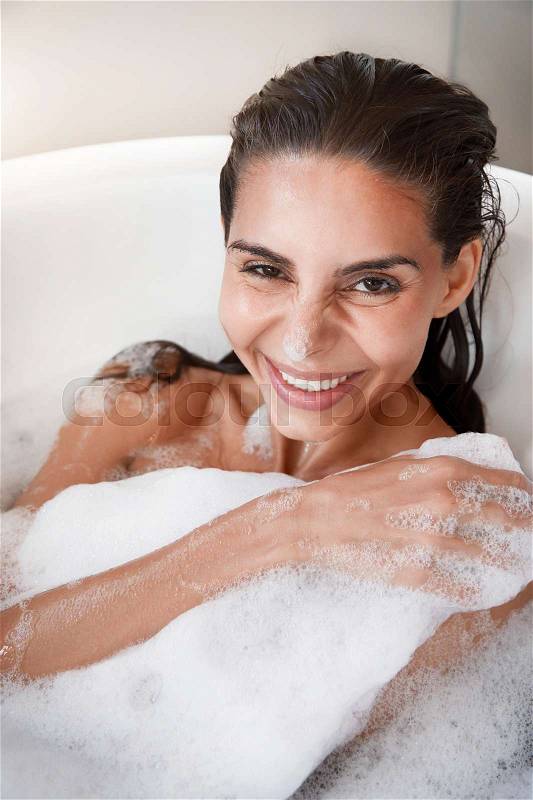 Beautiful woman smiling in bath tub, portrait, stock photo