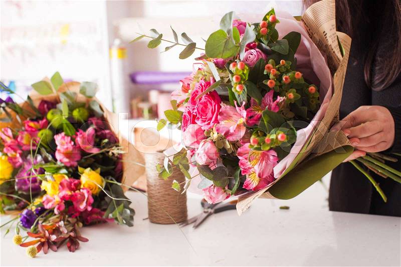 Florist making fashion bouquet of pink flowers, stock photo