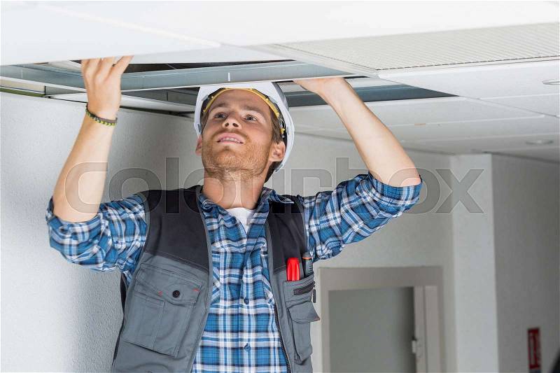Electrical worker wiring in ceiling, stock photo