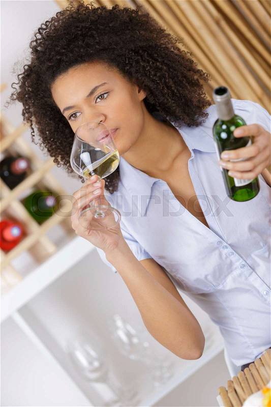 Woman drinking white wine at restaurant, stock photo