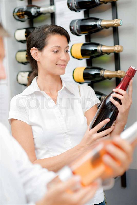 Woman selecting a bottle of wine, stock photo