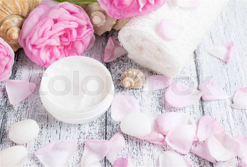 Spa salon with cream, towel and roses on the wooden board, stock photo