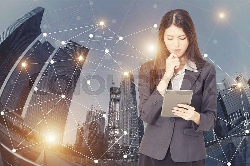 Close of businesswoman thinking about business plan with tablet in hand and connection lines on cityscape background. Smart worldwide connection people concept. E-commerce business, stock photo