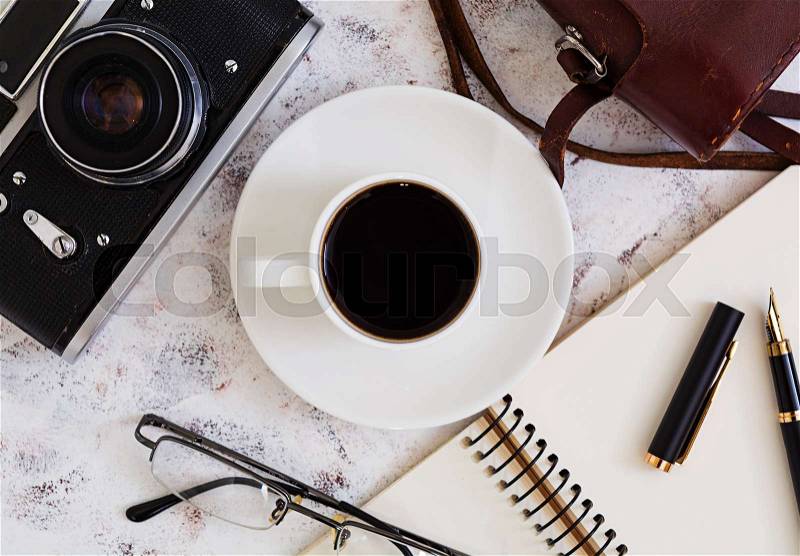Flat lay, top view office table desk. Desk workspace with retro camera, diary, pen, glasses, case, cup of coffee on white background, stock photo