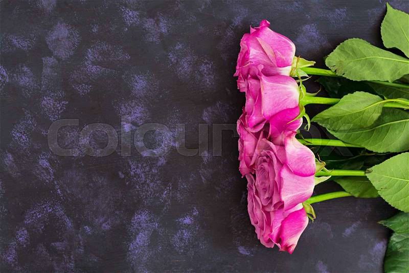 Bouquet of purple roses on a dark background. Top view, stock photo