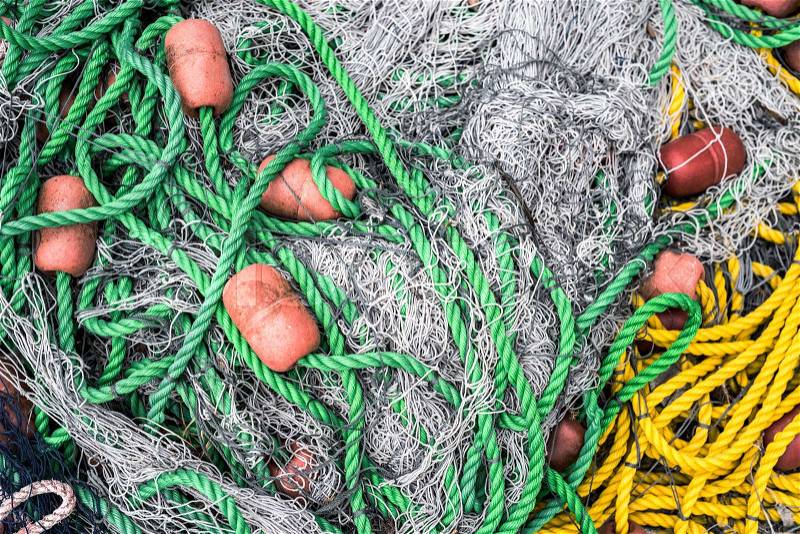 Pile of fishing nets with floats and colorful nylon ropes, stock photo