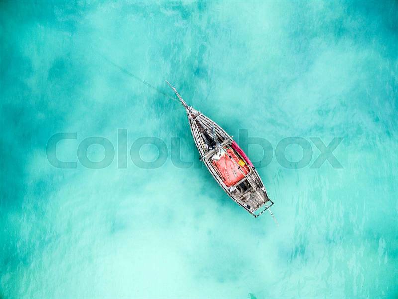 Lonely fishing boat in clean turquoise ocean, aerial photo, top view, stock photo
