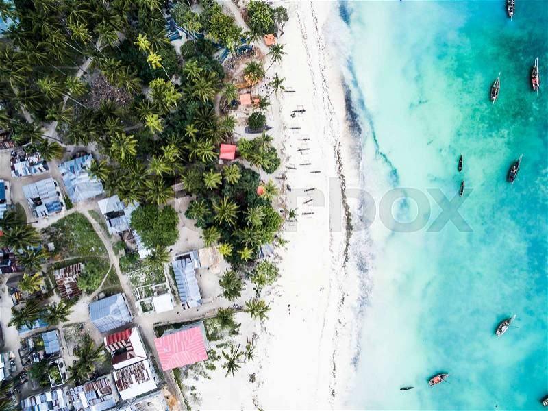 Beautiful turquoise ocean meets african island with houses and palms on Zanzibar, aerial photo, top view, stock photo