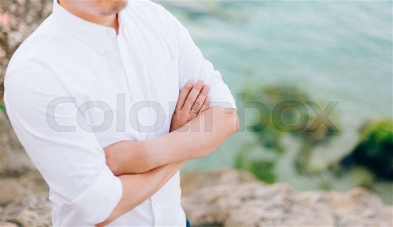 Male hands crossed on chest. Hands of the groom on the chest, stock photo