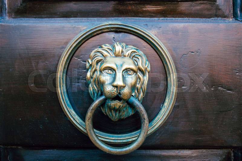 Lion door knocker on the red wooden door, stock photo