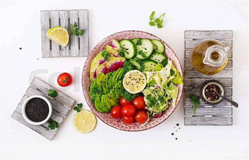 Diet menu. Healthy lifestyle. Vegan salad of fresh vegetables - tomatoes, cucumber, watermelon radish and avocado on bowl. Flat lay. Top view, stock photo