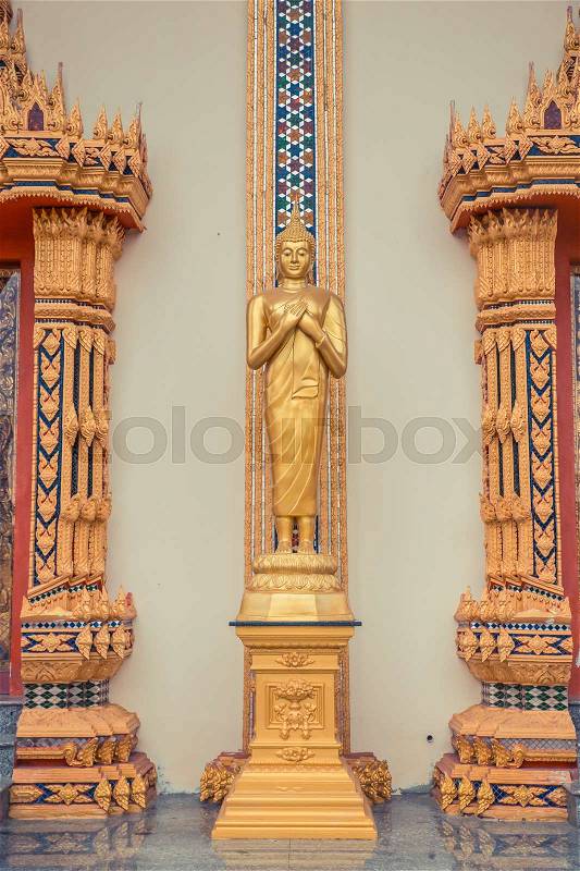 Ancient Thai temple. Wat Kosit Wihan golden Temple Phuket, Thailand. Golden buddha statue on the wall, stock photo