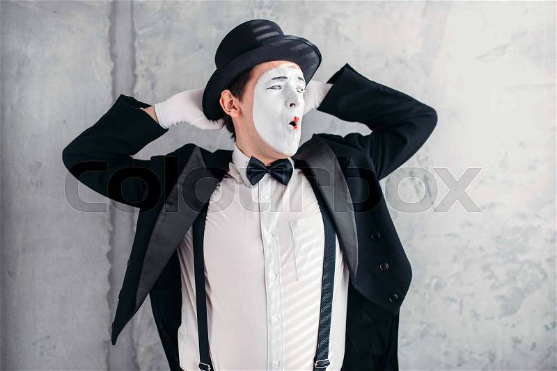 Pantomime artist with makeup mask. Mime in suit, gloves and hat. April fools day concept, stock photo