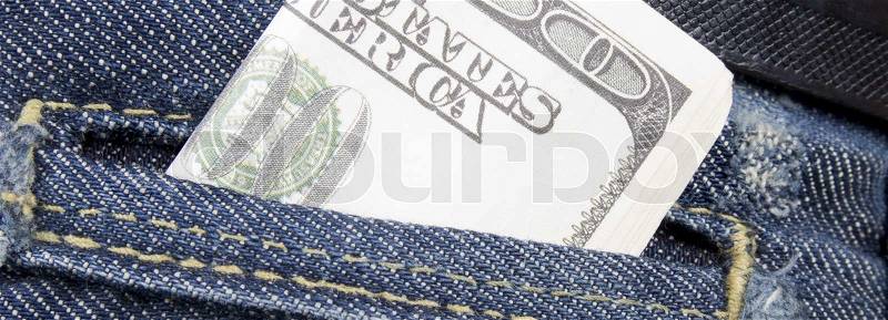 Stack of dollar bills in jeans pocket, stock photo