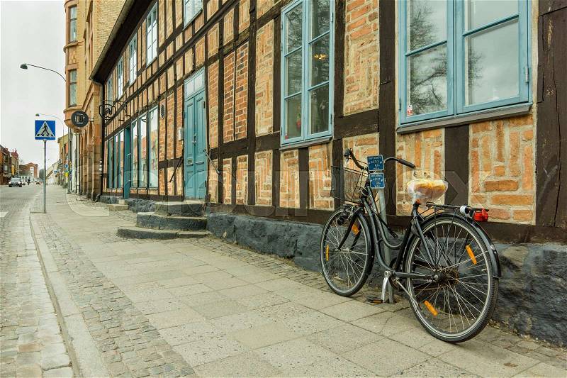 Retro bike standing against a wall of an old half timberd house in Lund, Sweden - Mars 25, 2017, stock photo