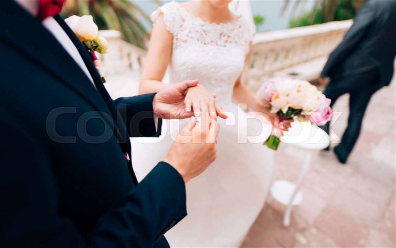 The groom dresses a ring on the finger of the bride at a wedding ceremony. Wedding in Montenegro, stock photo