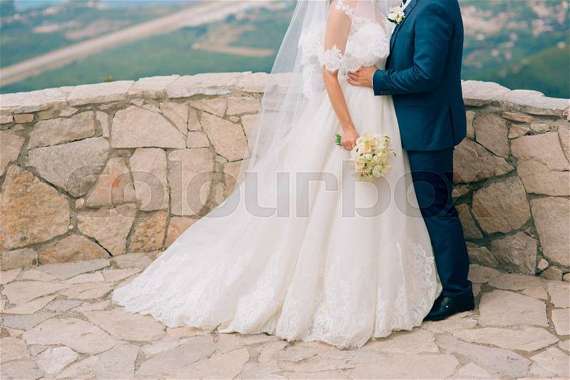 The groom embraces the bride in the mountains. Wedding in Montenegro and Croatia, stock photo