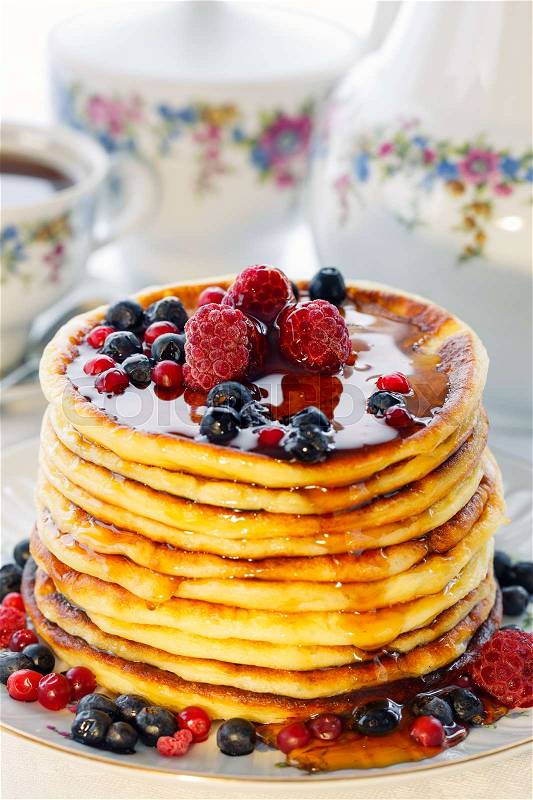 Pancakes with berries and honey, high key, stock photo