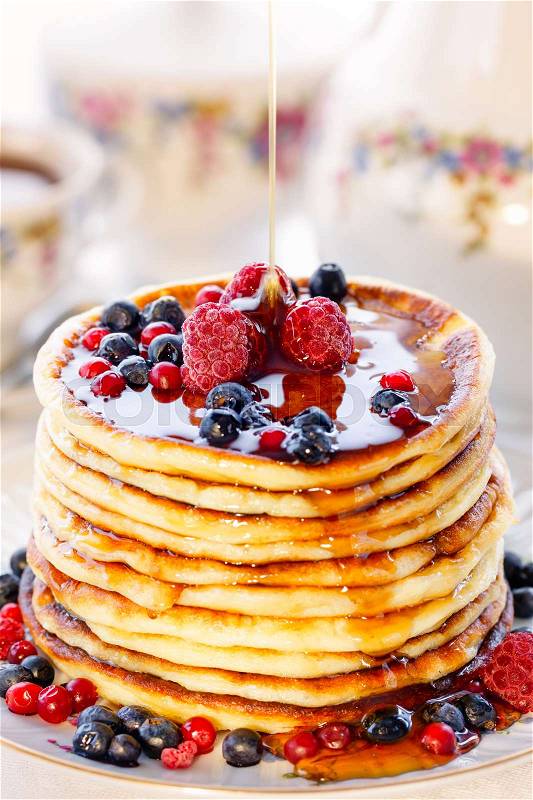 Pancakes with berries and honey, high key, stock photo