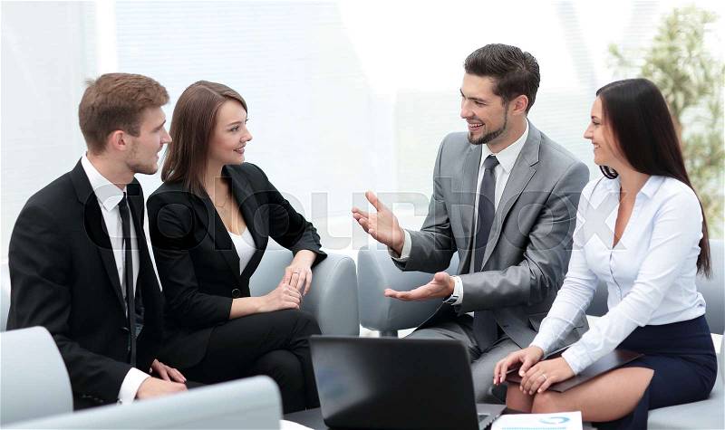 Group of young business people gathered together discussing a new project, stock photo