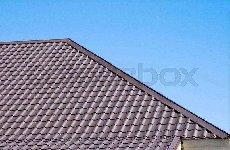Brown roof of metal roofing on the sky background, stock photo