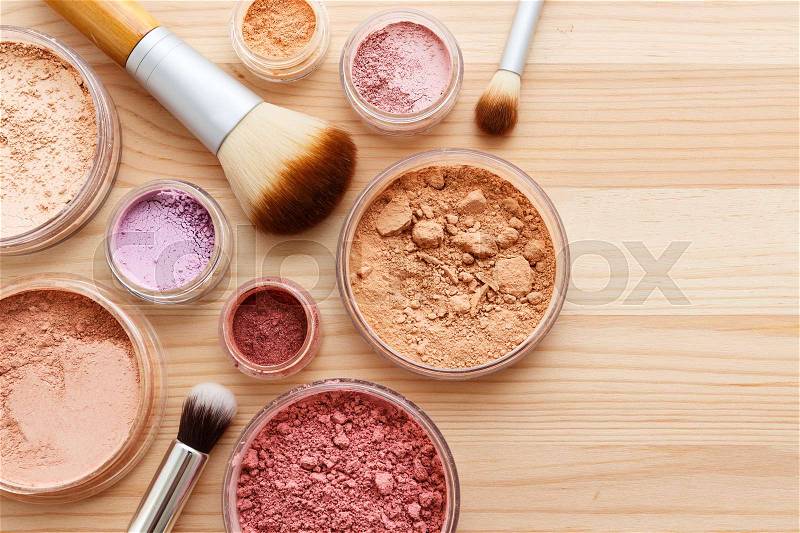 Makeup powder with foundation eye shadow and brushes on wood background, stock photo