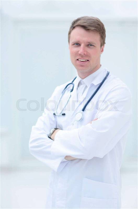 Portrait of confident male doctor with arms crossed standing at, stock photo